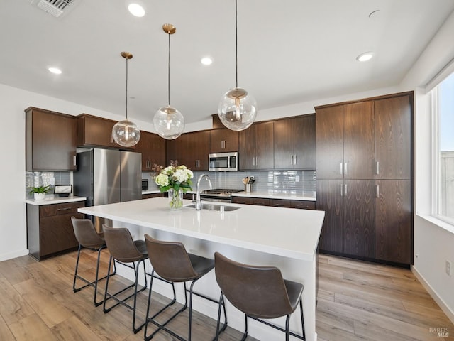 2471 Lake Club Dr, Fairfield, CA 94533 - kitchen with stainless steel appliances, a sink, backsplash, a breakfast bar area, and recessed lighting