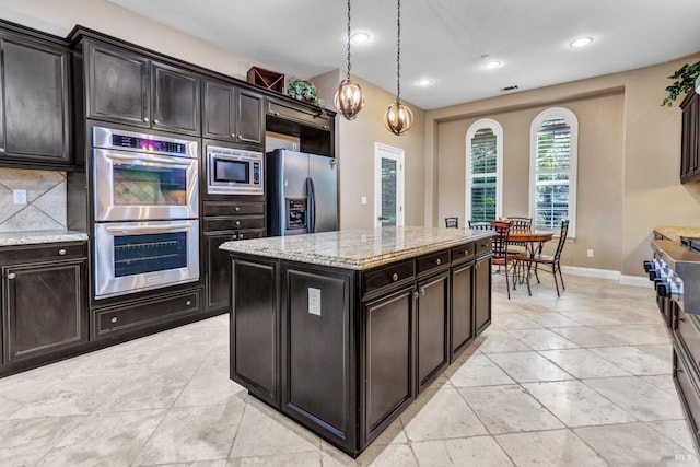 819 Bridle Ridge Dr, Fairfield, CA 94534 - kitchen with appliances with stainless steel finishes, tasteful backsplash, light stone counters, hanging light fixtures, and baseboards