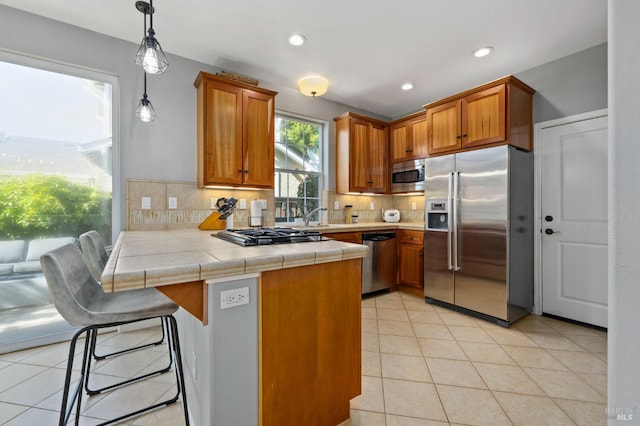 2817 Windmill Dr, Santa Rosa, CA 95403 - kitchen featuring appliances with stainless steel finishes, a peninsula, brown cabinetry, tasteful backsplash, and recessed lighting