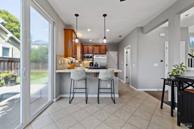 2817 Windmill Dr, Santa Rosa, CA 95403 - kitchen with appliances with stainless steel finishes, a peninsula, brown cabinetry, light tile patterned floors, and healthy amount of natural light