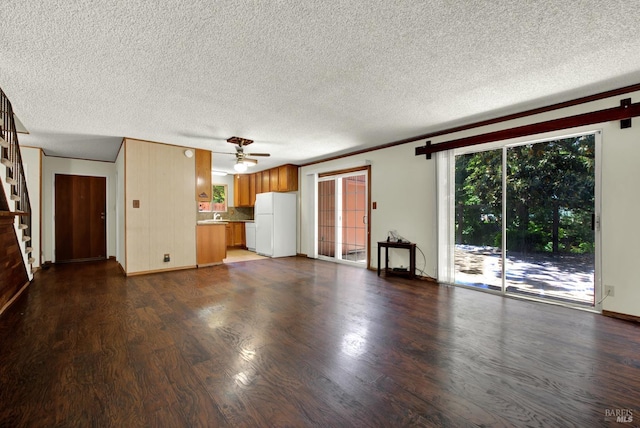 970 El Camino Ave Unit 3, Vacaville, CA 95688 - unfurnished living room with dark wood finished floors, a ceiling fan, a textured ceiling, stairs, and baseboards