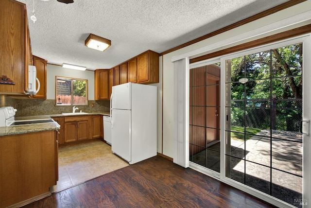 970 El Camino Ave Unit 3, Vacaville, CA 95688 - kitchen with white appliances, decorative backsplash, brown cabinetry, a sink, and light wood-style flooring