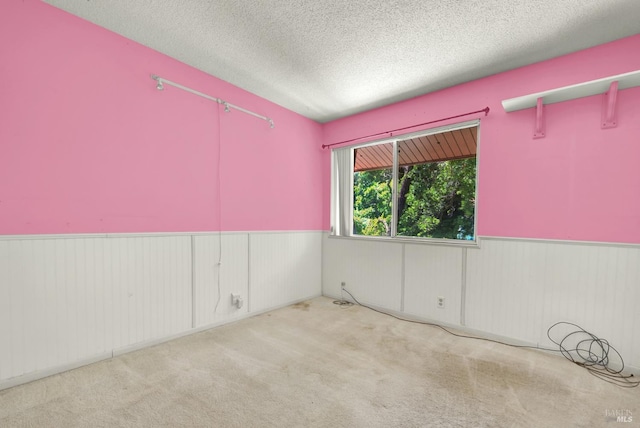 970 El Camino Ave Unit 3, Vacaville, CA 95688 - empty room featuring wainscoting, a textured ceiling, and carpet floors