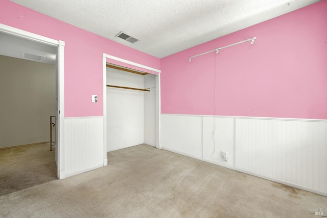 970 El Camino Ave Unit 3, Vacaville, CA 95688 - unfurnished bedroom with a wainscoted wall, carpet flooring, a textured ceiling, and a closet