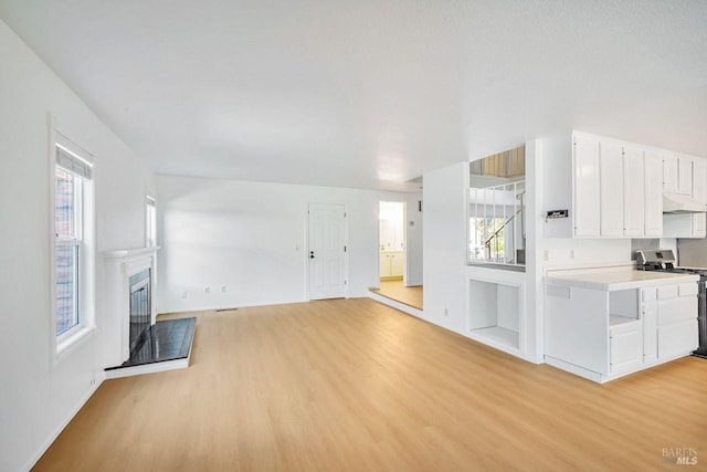 5705 Dexter Cir, Rohnert Park, CA 94928 - unfurnished living room with light wood-type flooring, plenty of natural light, and a glass covered fireplace