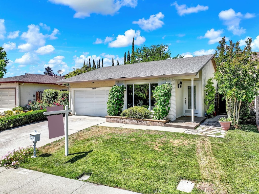 4553 Wildcat Ln, Concord, CA 94521 - ranch-style home featuring a garage, driveway, stucco siding, and a front lawn