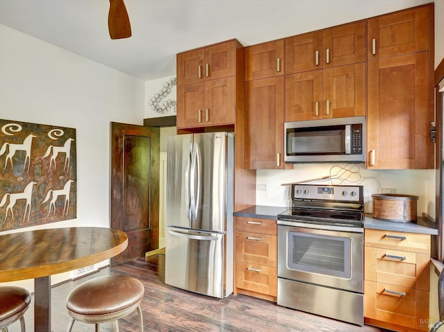 1011 Georgia St, Vallejo, CA 94590 - kitchen featuring appliances with stainless steel finishes, dark wood-type flooring, dark countertops, a ceiling fan, and brown cabinetry