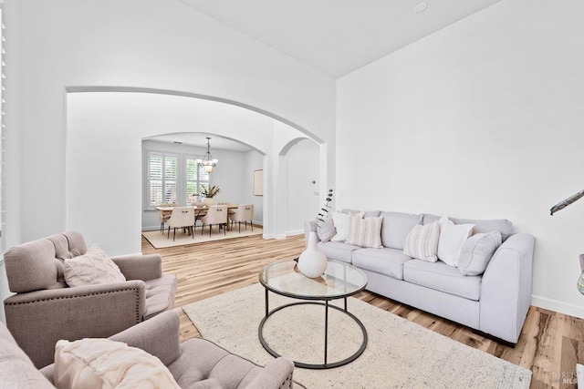 201 Red Pheasant Dr, Vacaville, CA 95687 - living room with arched walkways, a chandelier, wood finished floors, baseboards, and high vaulted ceiling