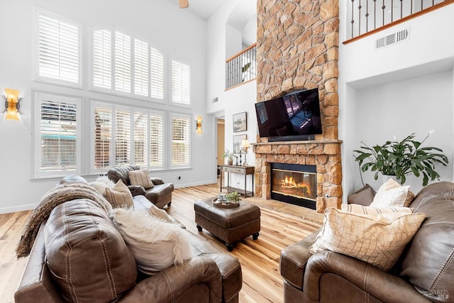 201 Red Pheasant Dr, Vacaville, CA 95687 - living room featuring a stone fireplace, a high ceiling, wood finished floors, and baseboards