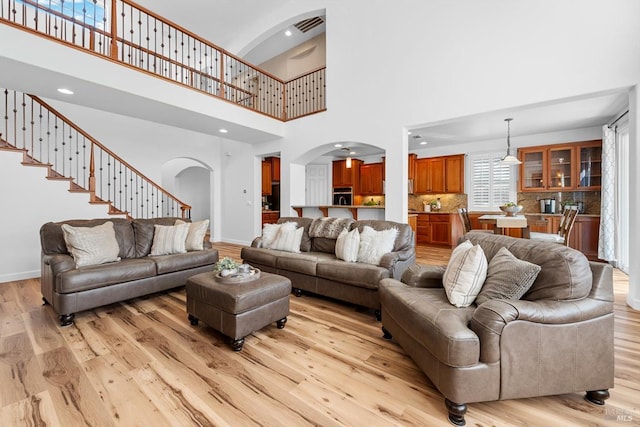 201 Red Pheasant Dr, Vacaville, CA 95687 - living area featuring arched walkways, a towering ceiling, light wood finished floors, baseboards, and recessed lighting