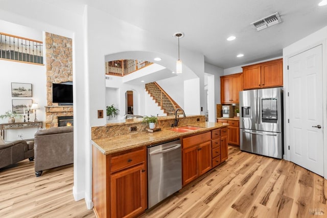 201 Red Pheasant Dr, Vacaville, CA 95687 - kitchen featuring appliances with stainless steel finishes, a sink, arched walkways, open floor plan, and light wood-style flooring