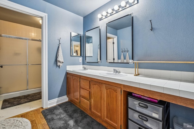 548 Bass Dr, Vacaville, CA 95687 - full bath with double vanity, wood finished floors, and an enclosed shower