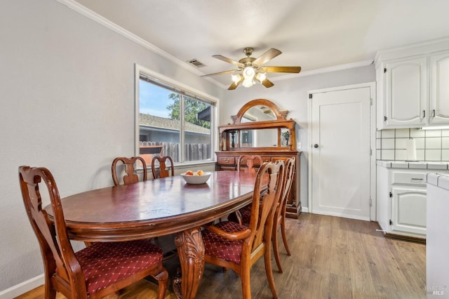 548 Bass Dr, Vacaville, CA 95687 - dining area featuring light wood-style flooring, ceiling fan, and crown molding