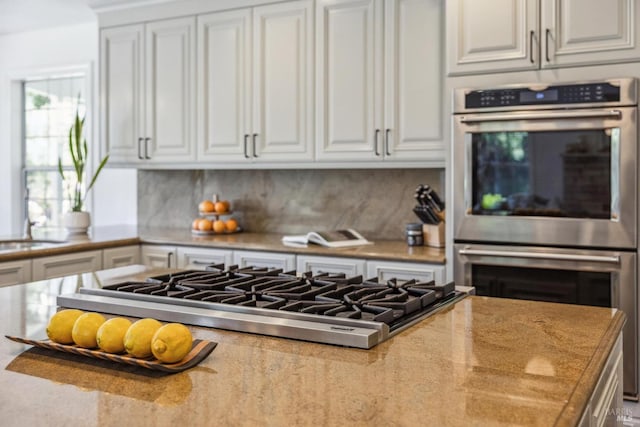 9724 Green Valley Rd, Sebastopol, CA 95472 - kitchen featuring double oven, cooktop, white cabinets, and decorative backsplash