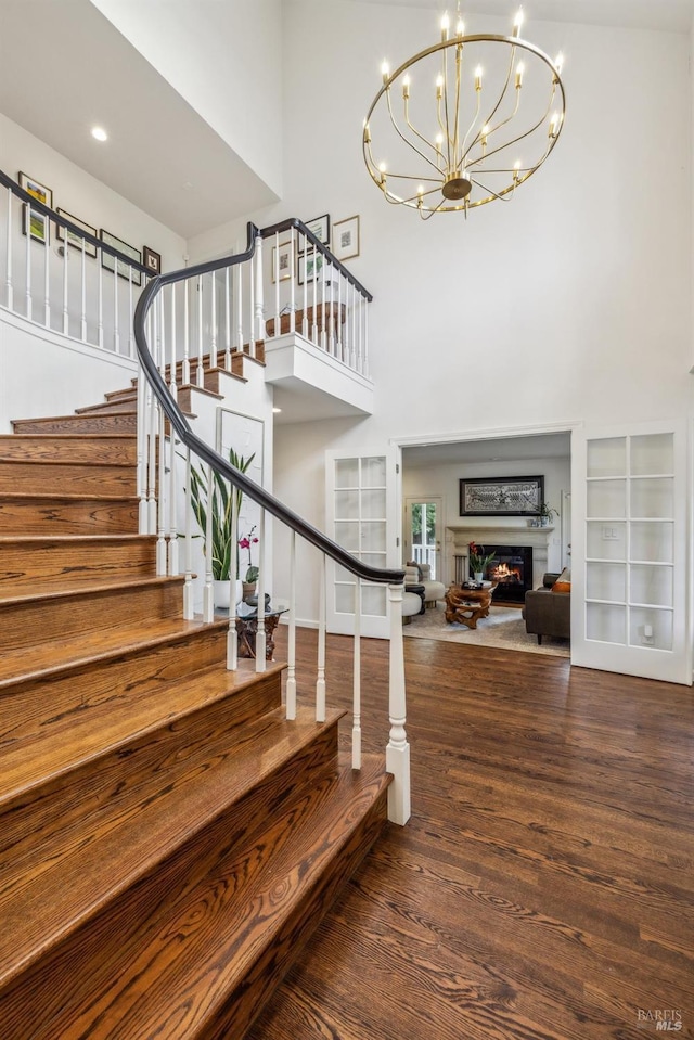 9724 Green Valley Rd, Sebastopol, CA 95472 - stairway with a high ceiling, wood finished floors, a chandelier, and a warm lit fireplace