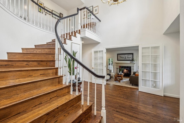 9724 Green Valley Rd, Sebastopol, CA 95472 - stairway featuring a towering ceiling, wood finished floors, a warm lit fireplace, and baseboards