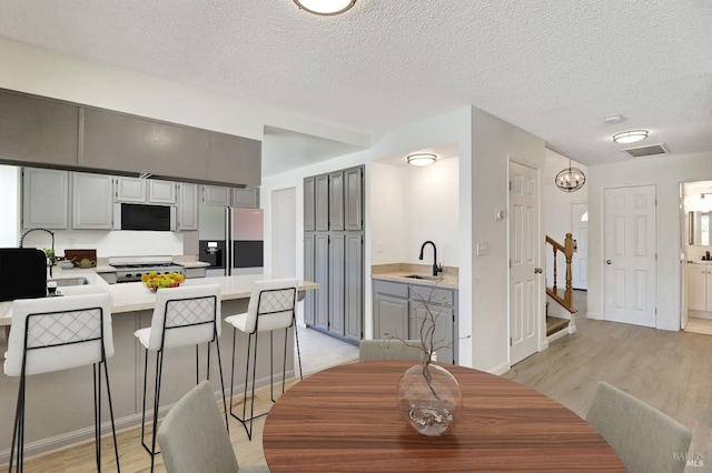 181 Belvedere Ct, Vallejo, CA 94589 - dining room featuring light wood-style floors, a textured ceiling, and stairs