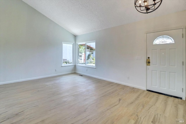 181 Belvedere Ct, Vallejo, CA 94589 - entryway with a chandelier, vaulted ceiling, wood finished floors, a textured ceiling, and baseboards