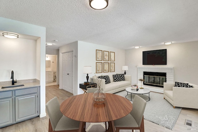 181 Belvedere Ct, Vallejo, CA 94589 - living area with light wood-style flooring, a brick fireplace, and a textured ceiling