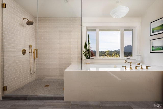 bathroom with a stall shower, a garden tub, and tile patterned flooring