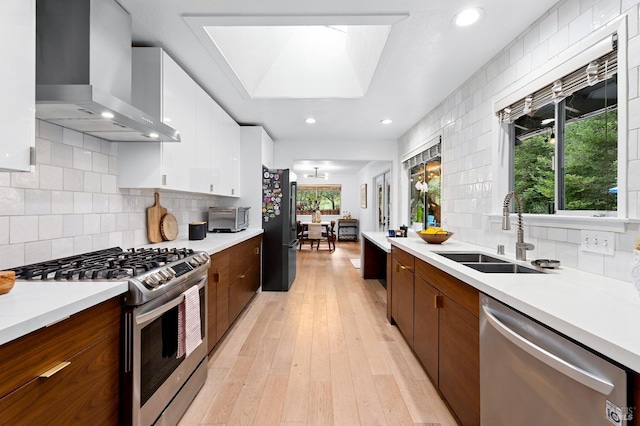 4512 Dry Creek Rd, Napa, CA 94558 - kitchen with appliances with stainless steel finishes, wall chimney range hood, a sink, white cabinetry, and light countertops