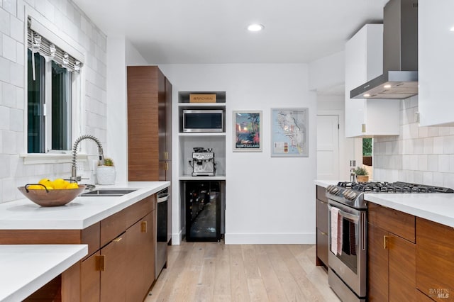 4512 Dry Creek Rd, Napa, CA 94558 - kitchen with stainless steel appliances, wall chimney exhaust hood, wine cooler, a sink, and light wood-style flooring