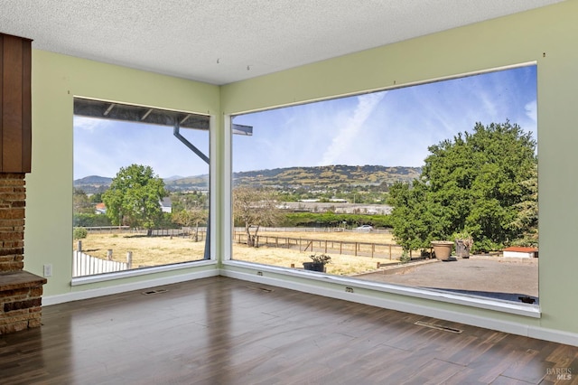 4335 Bodega Ave, Petaluma, CA 95942 - empty room featuring a mountain view, wood finished floors, baseboards, and a textured ceiling