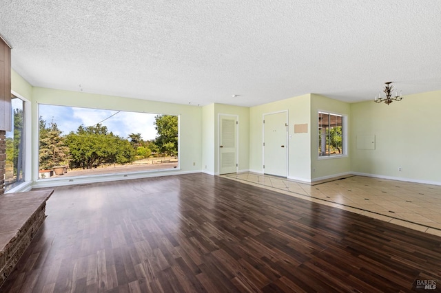 4335 Bodega Ave, Petaluma, CA 95942 - unfurnished living room featuring a textured ceiling, a chandelier, healthy amount of natural light, and wood finished floors