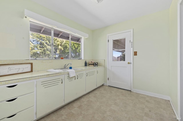 4335 Bodega Ave, Petaluma, CA 95942 - kitchen with decorative backsplash, light floors, light countertops, a sink, and baseboards
