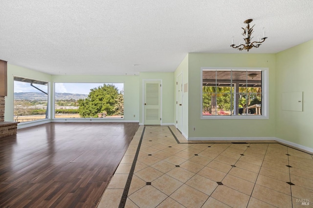 4335 Bodega Ave, Petaluma, CA 95942 - unfurnished living room with a textured ceiling, baseboards, a chandelier, and tile patterned floors