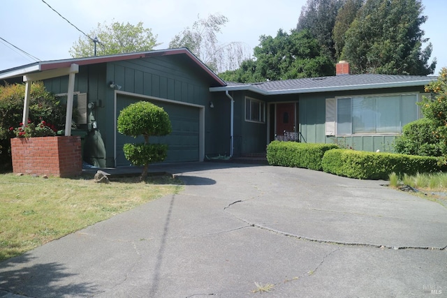 1021 Country Club Dr, Petaluma, CA 94952 - ranch-style house featuring a garage, asphalt driveway, a chimney, metal roof, and a front yard