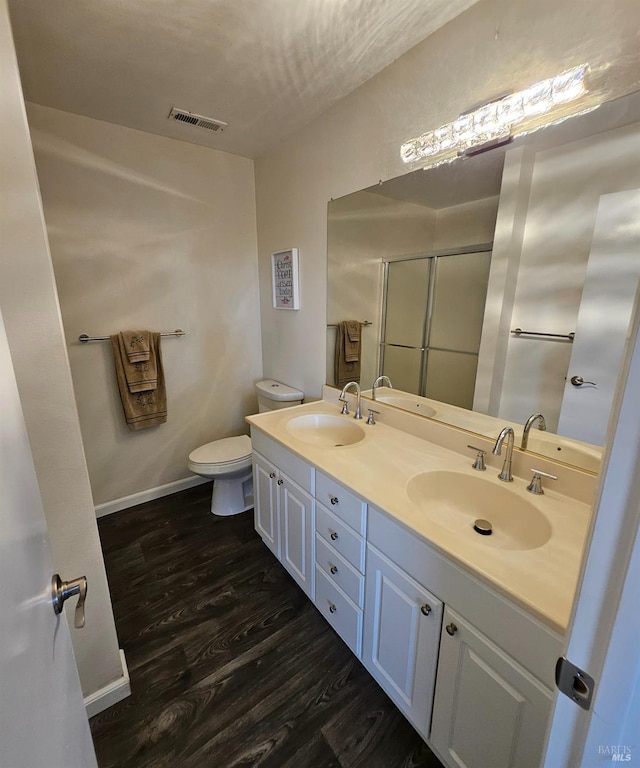 2145 Clearview Cir, Benicia, CA 94510 - full bathroom with wood finished floors, double vanity, a shower stall, toilet, and baseboards
