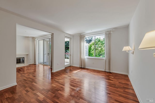 600 Deer Valley Rd Unit 1E, San Rafael, CA 94903 - spare room featuring a glass covered fireplace, wood finished floors, and baseboards