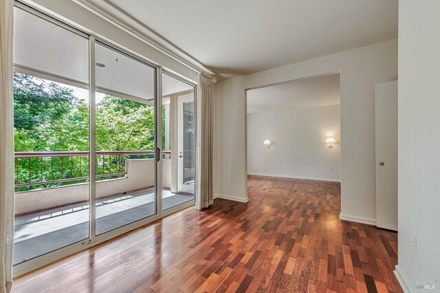600 Deer Valley Rd Unit 1E, San Rafael, CA 94903 - spare room featuring plenty of natural light, wood finished floors, and baseboards