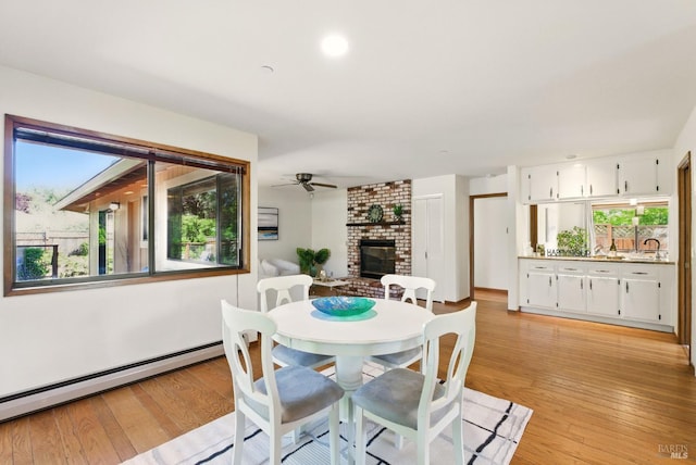 4620 Morris Ct, Santa Rosa, CA 95405 - dining space featuring a baseboard radiator, healthy amount of natural light, a brick fireplace, and light wood-style floors