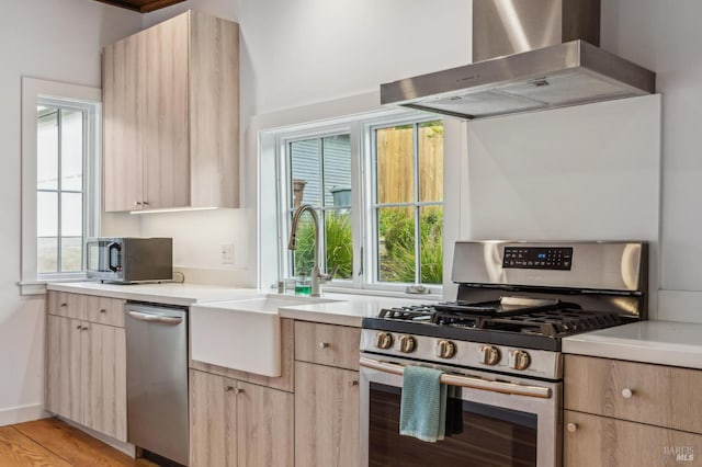 475 Molino Ave, Mill Valley, CA 94941 - kitchen featuring appliances with stainless steel finishes, wall chimney range hood, light brown cabinetry, a sink, and light countertops