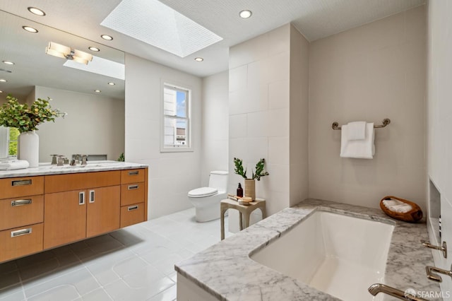 2111 Vallejo St, San Francisco, CA 94123 - bathroom featuring a skylight, toilet, vanity, a tub, and recessed lighting