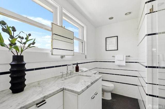 2111 Vallejo St, San Francisco, CA 94123 - bathroom with toilet, tile walls, vanity, a wainscoted wall, and tile patterned flooring