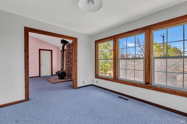 845 W K St, Benicia, CA 94510 - empty room featuring a wood stove, carpet flooring, baseboards, and vaulted ceiling