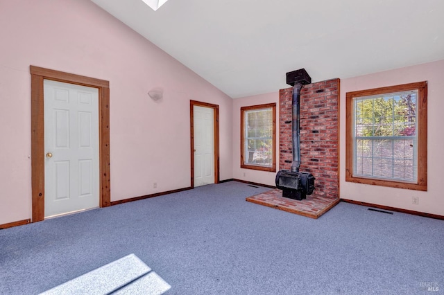 845 W K St, Benicia, CA 94510 - unfurnished living room with a wood stove, vaulted ceiling, carpet floors, and baseboards