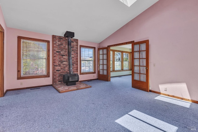 845 W K St, Benicia, CA 94510 - unfurnished living room with carpet, baseboards, a wood stove, and vaulted ceiling