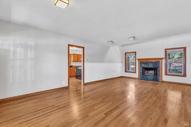 845 W K St, Benicia, CA 94510 - unfurnished living room featuring light wood finished floors, wainscoting, a high end fireplace, and baseboards