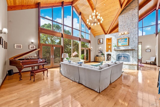 303 Mctavish Ct Unit A, Fairfield, CA 94534 - living room with high vaulted ceiling, wood ceiling with exposed beams, a stone fireplace, a chandelier, and french doors