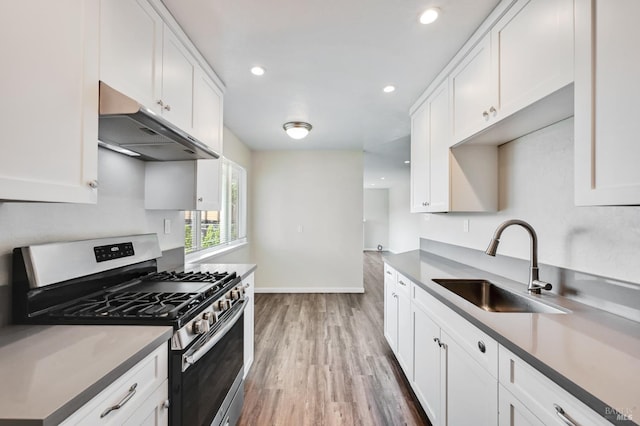 1313 Mcneil Ave, Petaluma, CA 94954 - kitchen with stainless steel gas range, under cabinet range hood, a sink, white cabinets, and recessed lighting