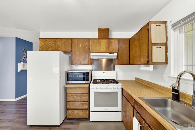 130 Ward Ct, Vallejo, CA 94589 - kitchen with white appliances, under cabinet range hood, a sink, brown cabinetry, and light countertops