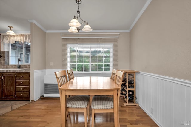 4538 Hill Rd, Lakeport, CA 95453 - dining space featuring light wood-style flooring, a wainscoted wall, ornamental molding, and a chandelier