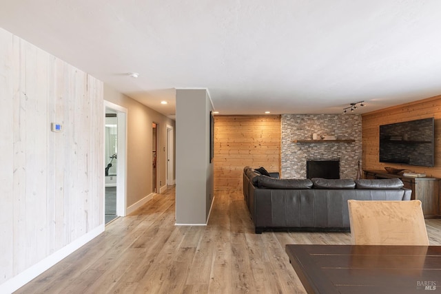 10505 Cherry Ridge Rd, Sebastopol, CA 95472 - living room with wood walls, a fireplace, light wood-type flooring, track lighting, and baseboards