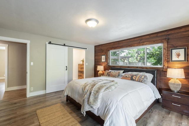10505 Cherry Ridge Rd, Sebastopol, CA 95472 - bedroom with a barn door, wood finished floors, and baseboards