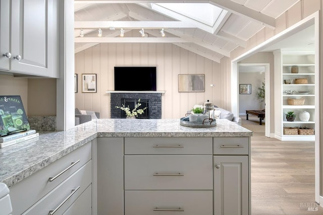 41 Salinas Ave, San Anselmo, CA 94960 - kitchen with open floor plan, light wood finished floors, a skylight, a brick fireplace, and light stone countertops