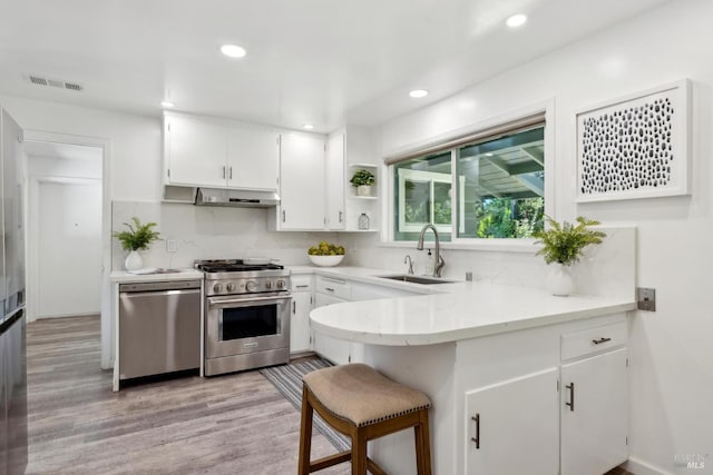 2120 Palmer Dr, Saint Helena, CA 94574 - kitchen with stainless steel appliances, a sink, under cabinet range hood, a peninsula, and light wood-style flooring